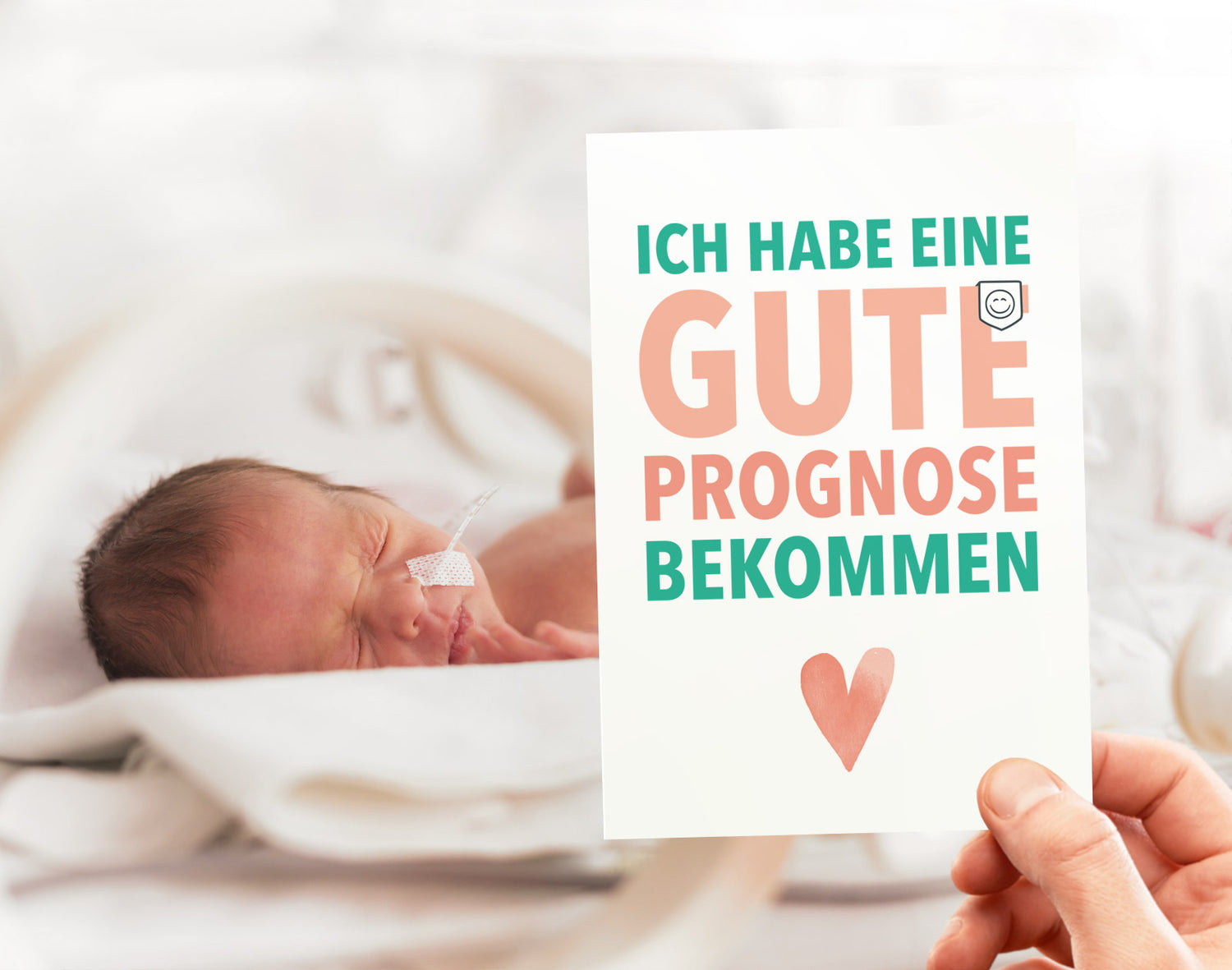 Bild eines Frühchen im Inkubator mit einer Meilensteinkarte im Vordergrund. Auf der arte steht "Ich habe eine gute Prognose bekommen"