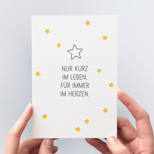 Ansicht der Grußkarte für tröstende Worte nach einer Fehlgeburt. Die Karte ist mit kleinen Sternen verziert und trägt den Aufdruck "Nur kurz im Leben, für immer im Herzen"