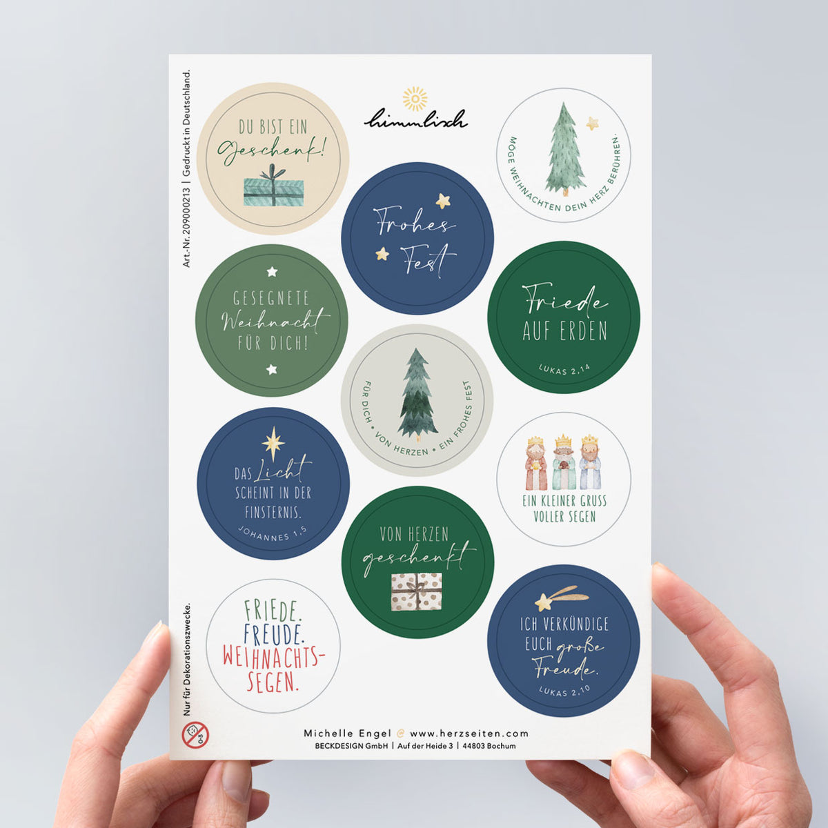 Weihnachtlicher Stickerbogen „von Herzen geschenkt" – 11 runde, vorgestanzte christliche Sticker in Dunkelblau, Tannengrün und Beige mit Bibelversen, Segenswünschen und Aquarell-Illustrationen (Tannenbäume, Heilige Drei Könige, Geschenke) – aus der himmlisch-Weihnachtskollektion von herzseiten.com.