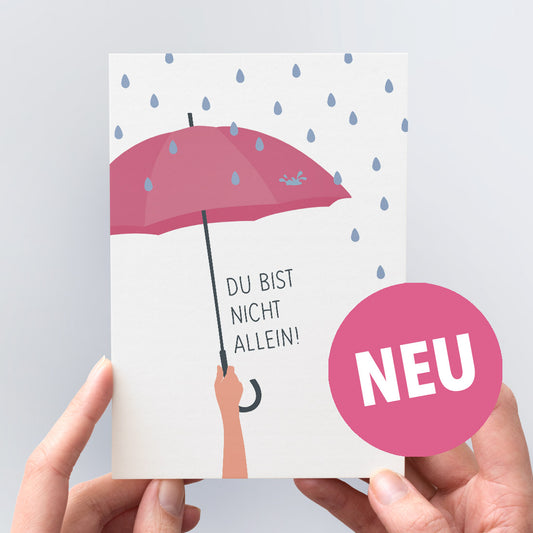 Trost-Postkarte "Du bist nicht allein" - Die Illustration zeigt eine Hand, die einen schützenden Regenschirm hält.