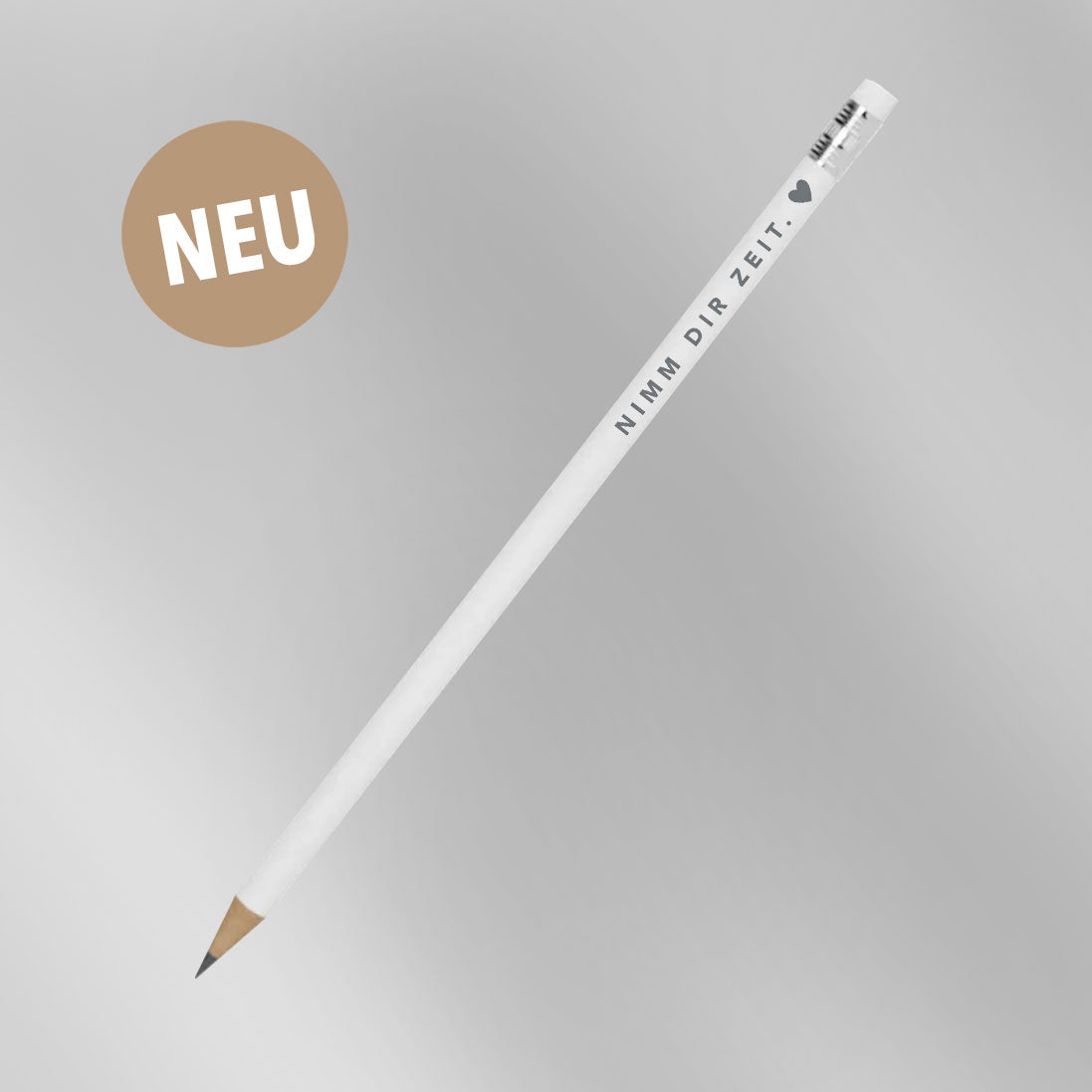 Weißer Bleistift mit grauem Aufdruck „Nimm dir Zeit. ♥" vor grauem Hintergrund mit NEU-Badge – neues Produkt aus der himmlisch-Kollektion von herzseiten.com.