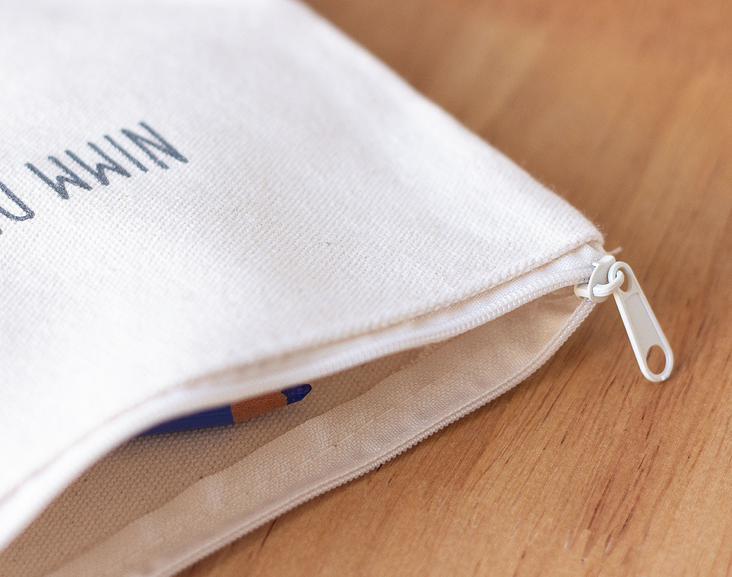 Detailaufnahme des Reißverschlusses am naturfarben Baumwolltäschchen „Nimm dir Zeit für dich und mich. Gott" mit sichtbarem Bleistift im Innenfutter – Täschchen aus der „Nimm dir Zeit"-Serie von herzseiten.com.